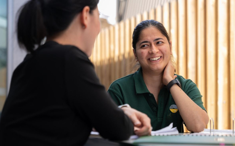 two women siting at a table having a friendly chat